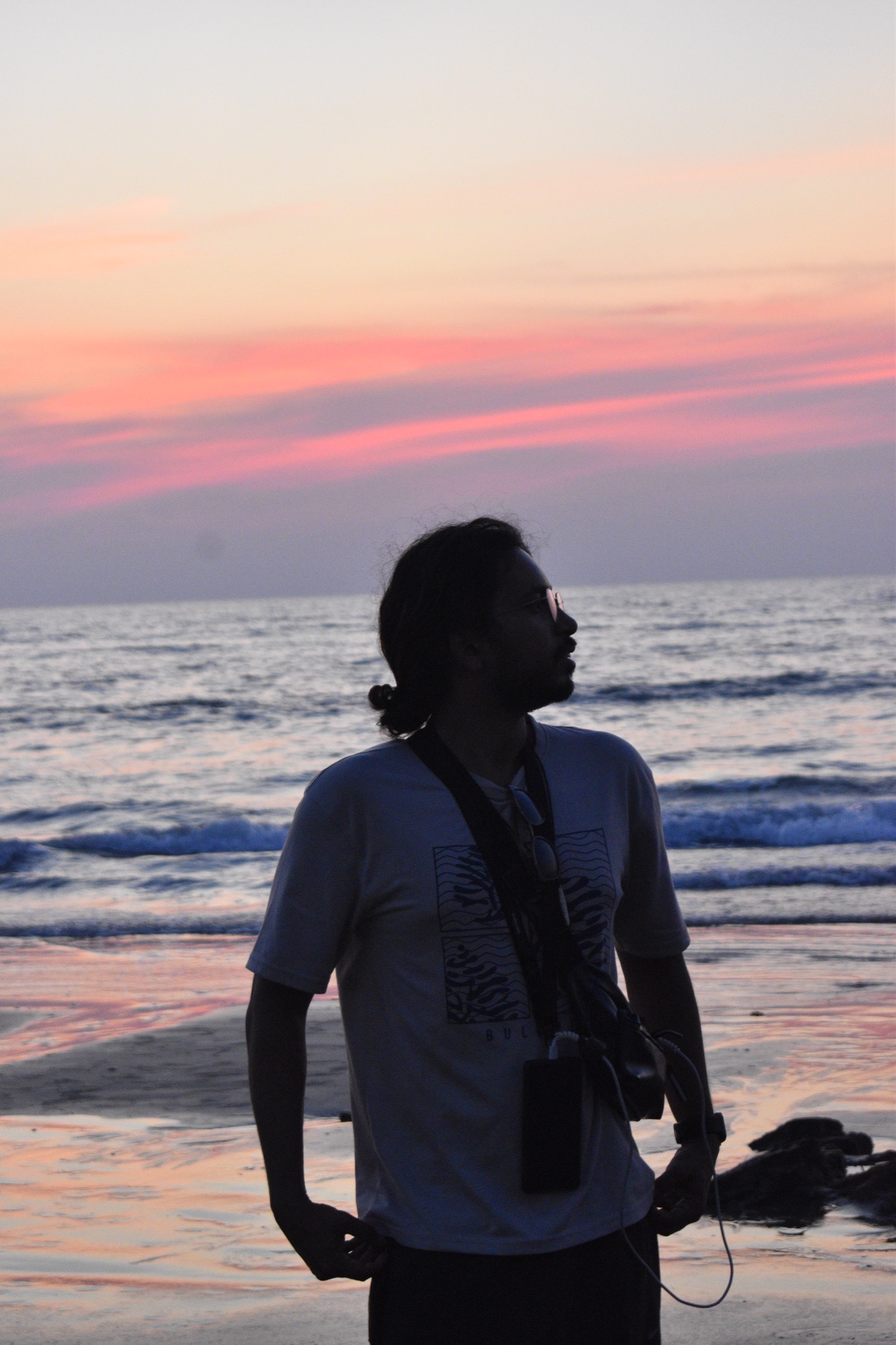 Silhouette against a vivid streak of sunset color over the ocean